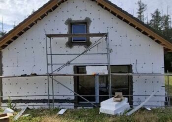 Rodinný dům ve fázi výstavby s nainstalovaným polystyrenovým zateplením a postaveným lešením