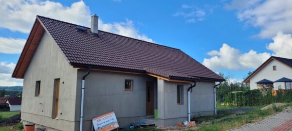 PHOTO-2025-01-10-20-03-42 Široký záběr na dům se strojní omítkou a dokončenou střechou.