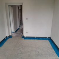 Místnost s plastovou fólií rozprostřenou na podlaze z jiného úhlu