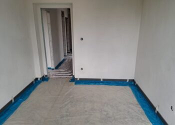 Místnost s plastovou fólií rozprostřenou na podlaze z jiného úhlu